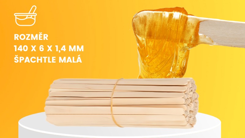 Svazek depilační špachtle malá na žlutém podkladu. Na špachtli je vosk.